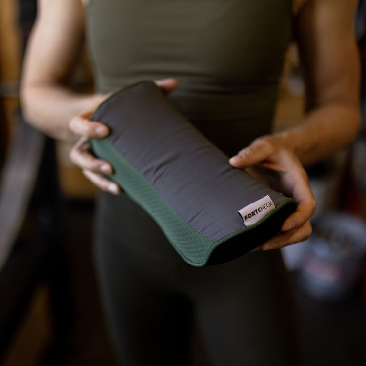 Closeup of a person holding the forteneck neck cushion in front of them