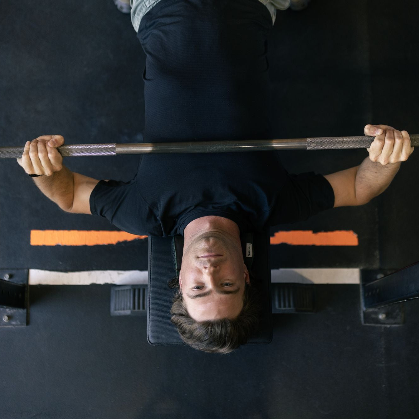 Man weight lifting with a barbell in a gym setting
